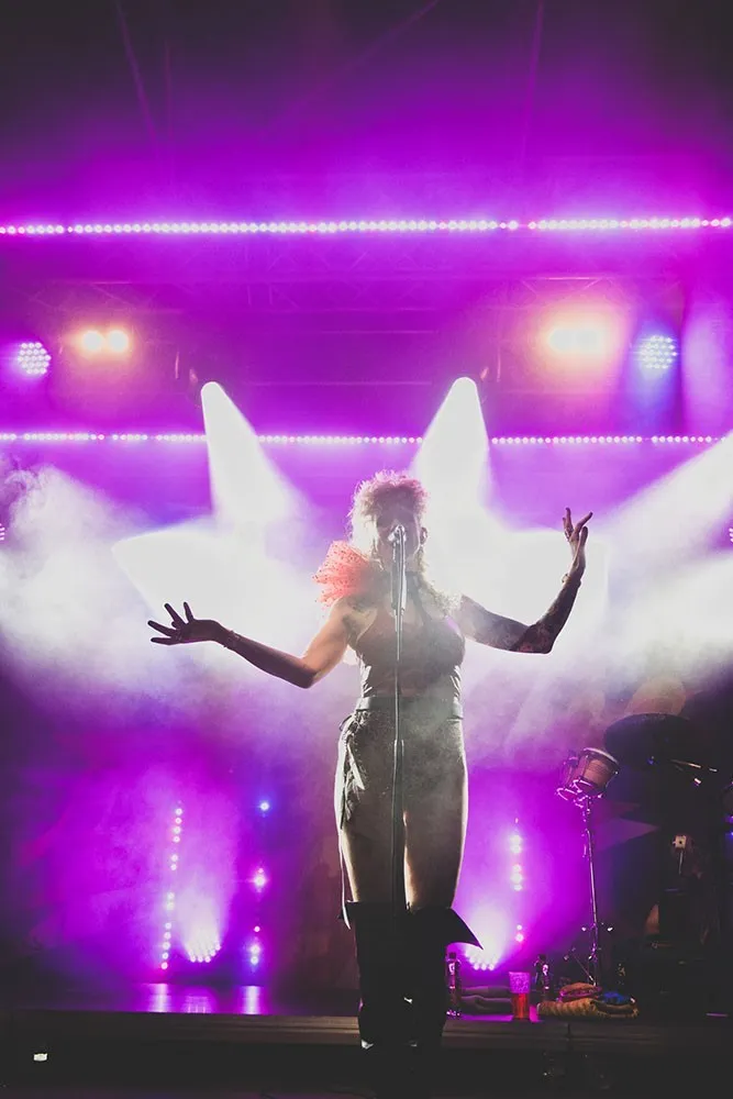 Ankathie Koi auf der Schaffarei Bühne mit lila Hintergrund