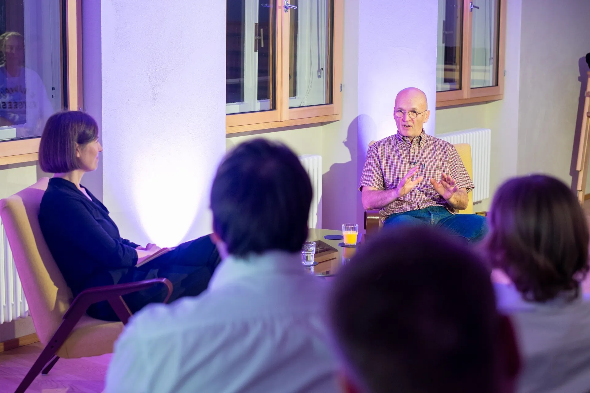 Moderatorin Carmen Jurkovic-Burtscher im Gespräch mit Holger Hansen. Publikum im Hintergrund.