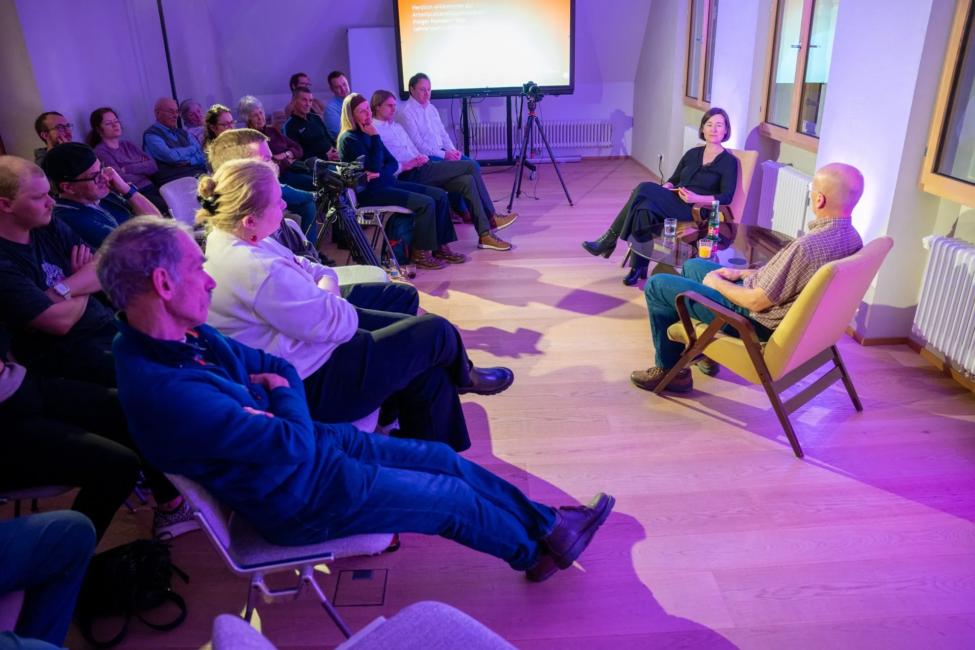 Moderatorin Carmen Jurkovic-Burtscher im Gespräch mit Holger Hansen. Publikum im Hintergrund.