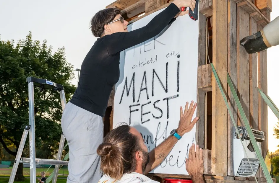 Künstlerin Christine Lederer bei Anbringung von Manifest der Zukunft der Arbeit