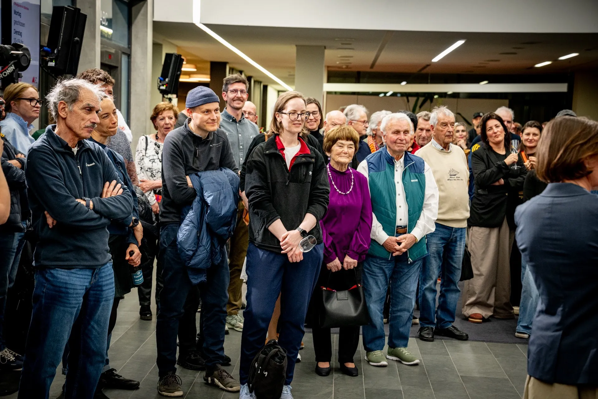 Besucherinnen und Besucher verfolgen aufmerksam das Programm bei der Vernissage zur Ausstellung „Museum des Wandels" der AK Vorarlberg.
