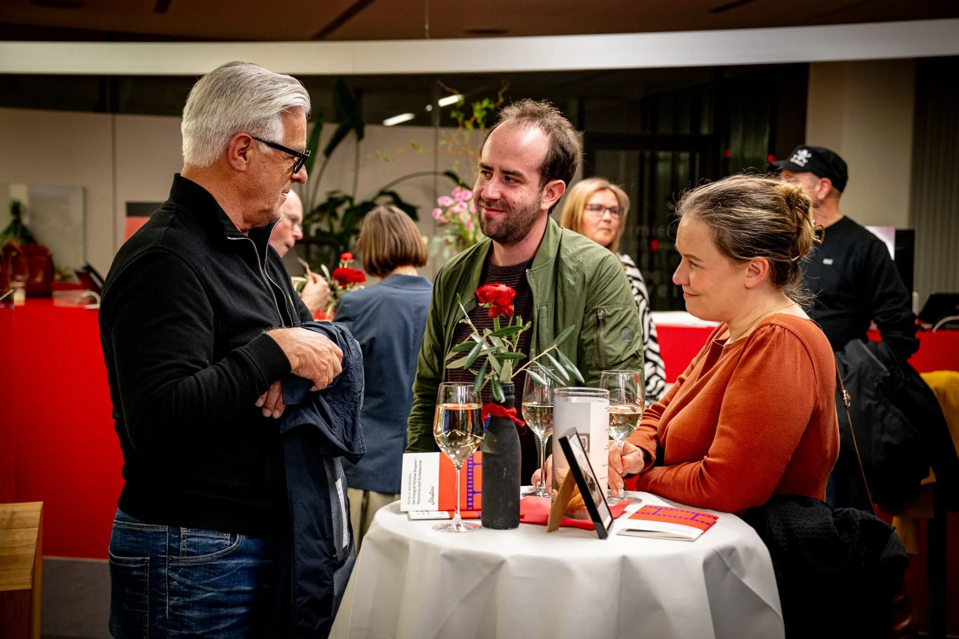 Besucherinnen und Besucher unterhalten sich am Rand der Vernissage zur Ausstellung „Museum des Wandels" der AK Vorarlberg.