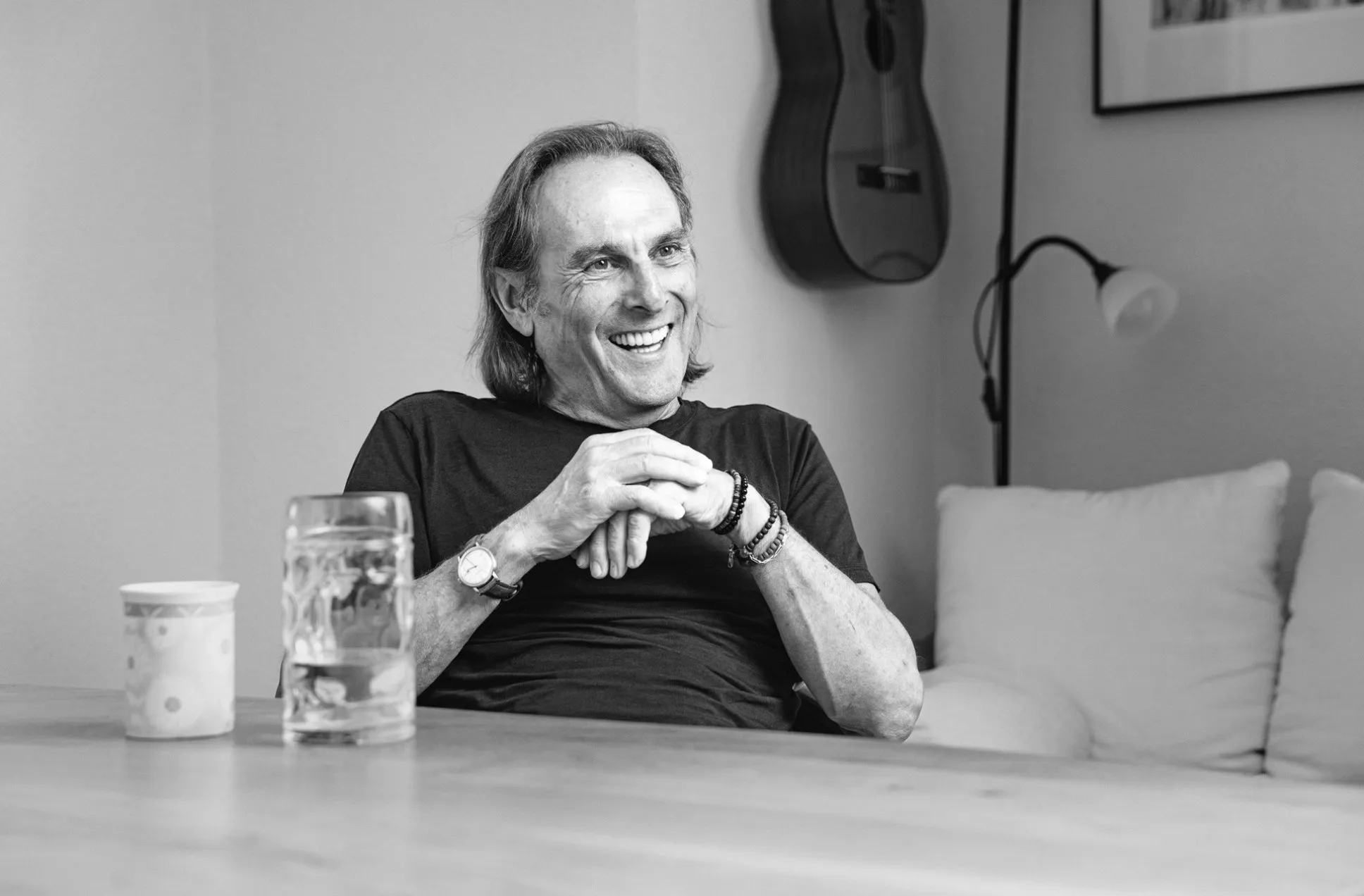 Hans Reichart lächelnd in seinem Wohnzimmer