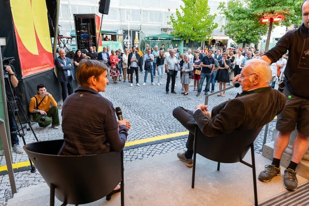 Michaela Feuerstein-Prasser im Gespräch mit Herrn Albrecht vor dem Schaffarei Haus mit Publikum
