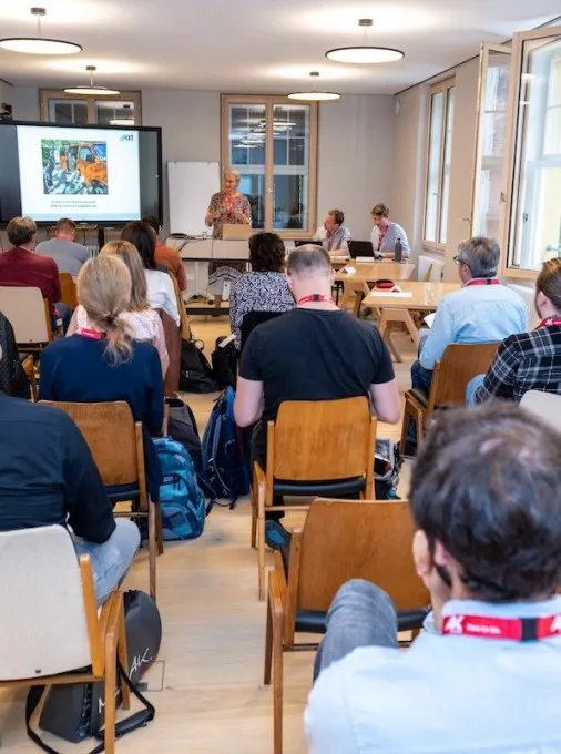 Seminarbesucher von hinten in einem Seminarraum der Schaffarei, Bildschirm und Vortragende sind vorne