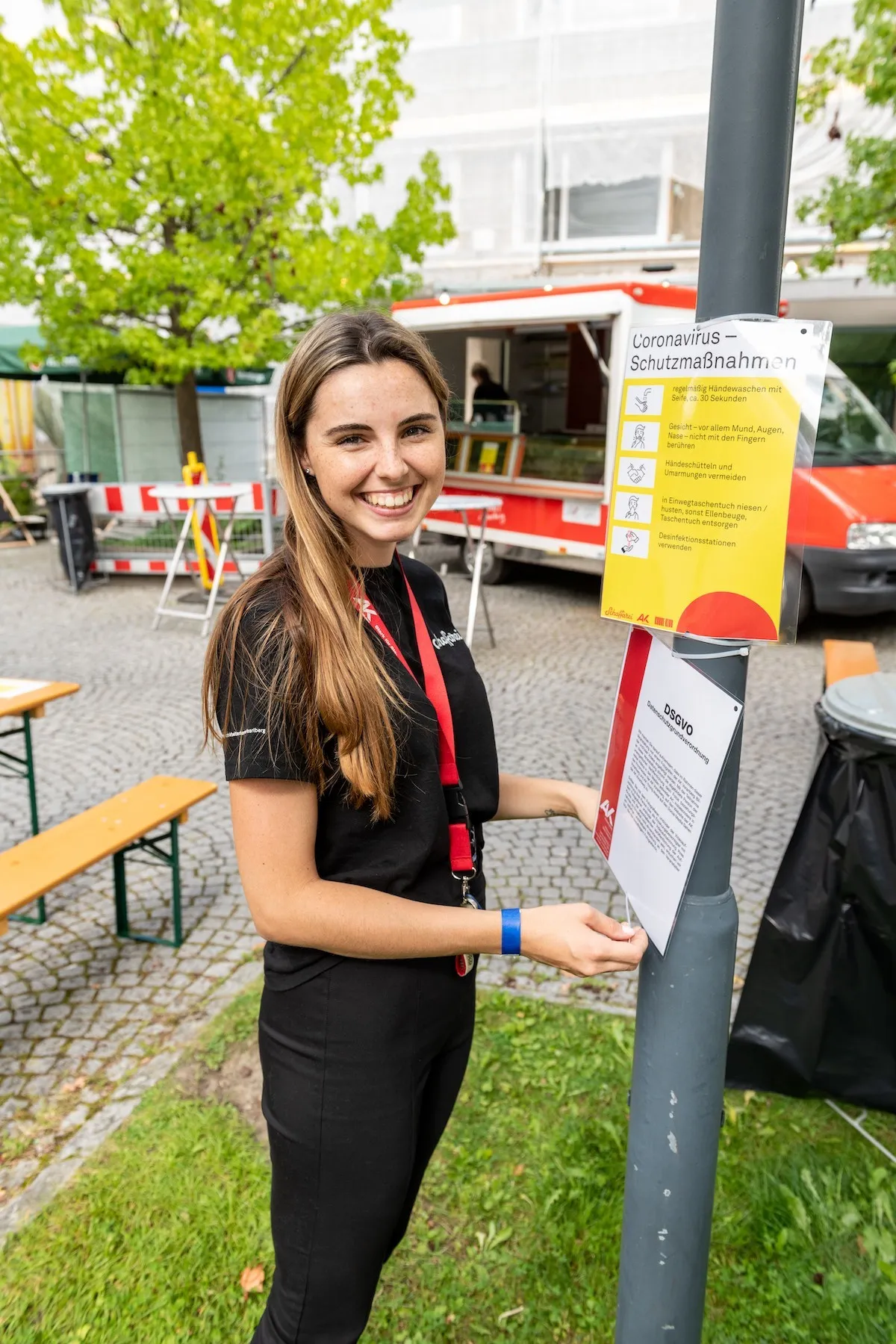 Lachende AK Mitarbeiterin beim Anbringen von Plakaten beim Schaffarei Festival