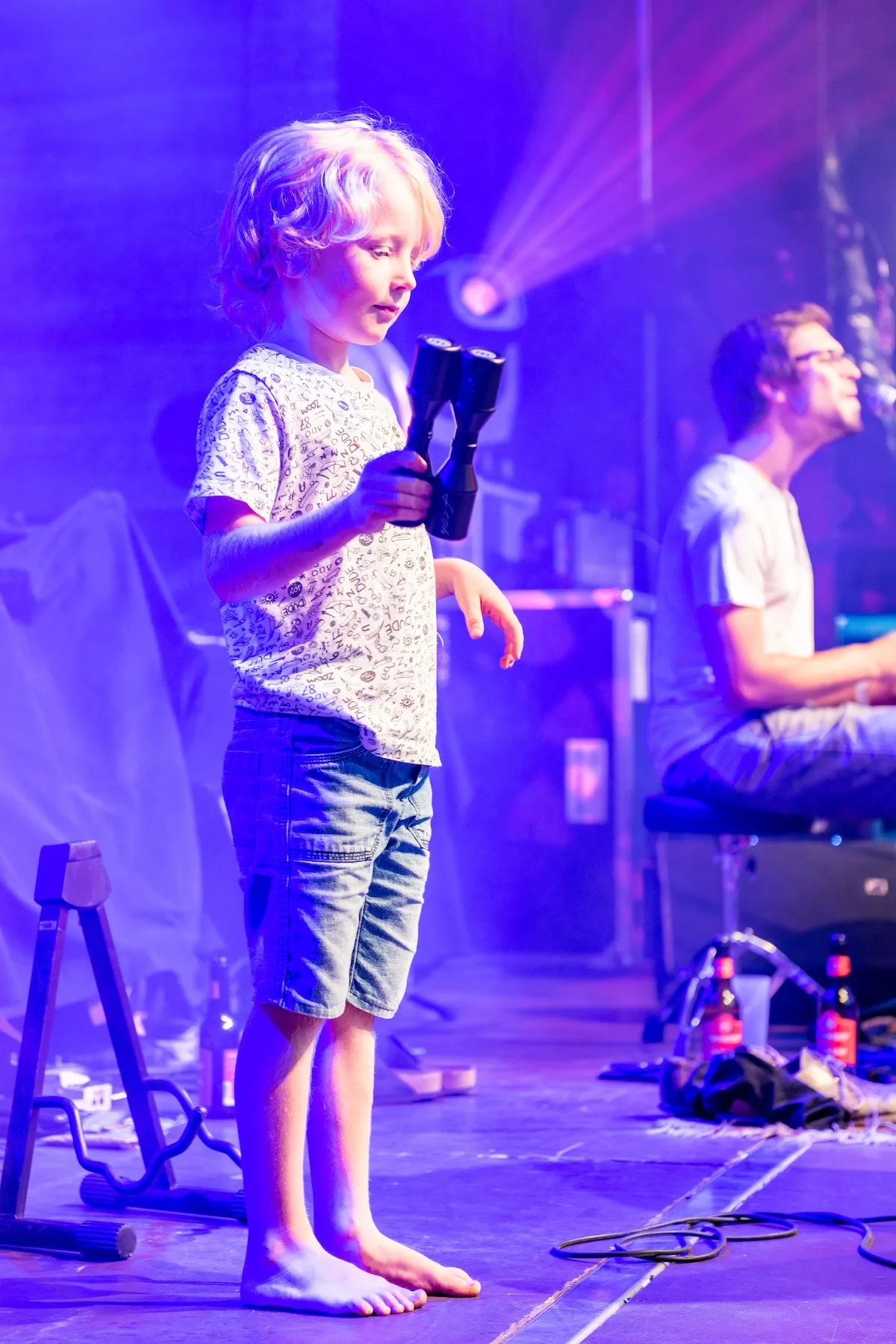 Kind auf der Bühne mit Rassel in der Hand