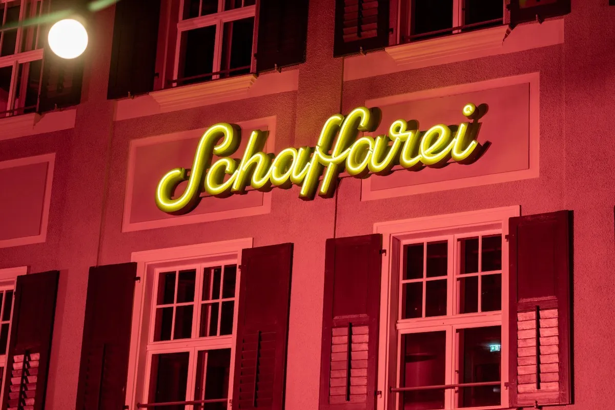 Beleutchtetes Schaffarei Logo am Haus