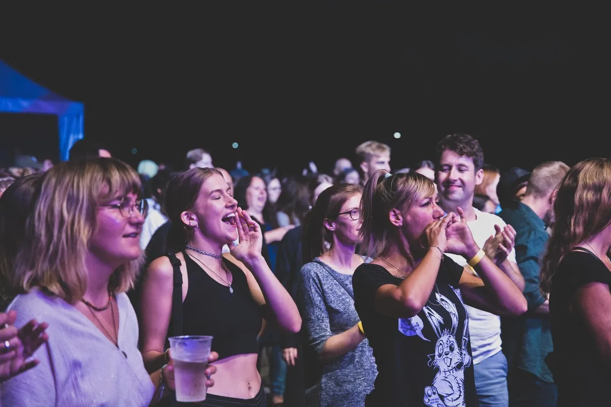 Glückliches Publikum am Tanzen und Singen