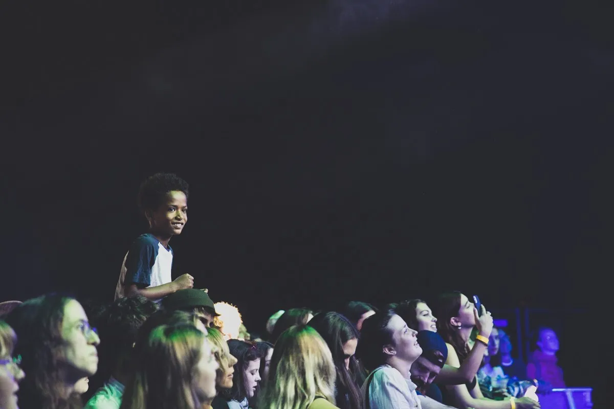 Publikum mit Kind auf Schulter