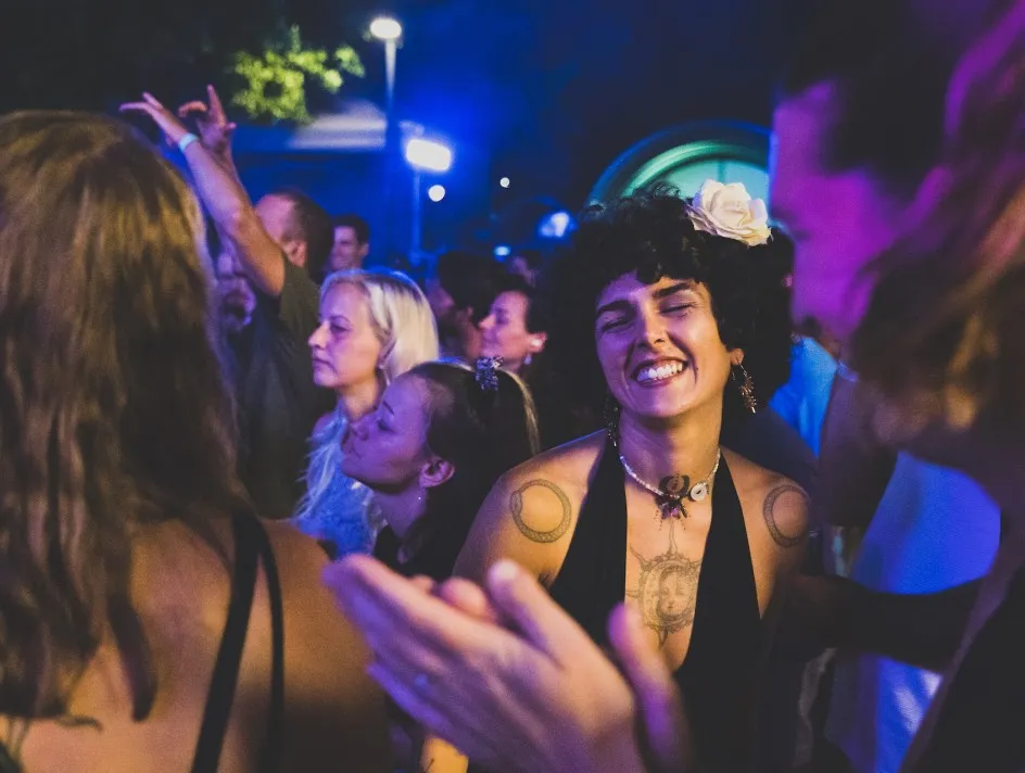 Tanzende Frau beim Schaffarei Festival im Hintergrunde eine Gruppe von Menschen