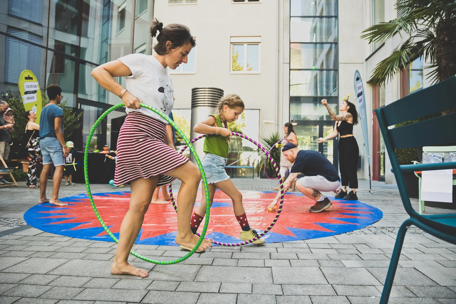 Frau und Kind beim üben mit Hula Hoop Reifen