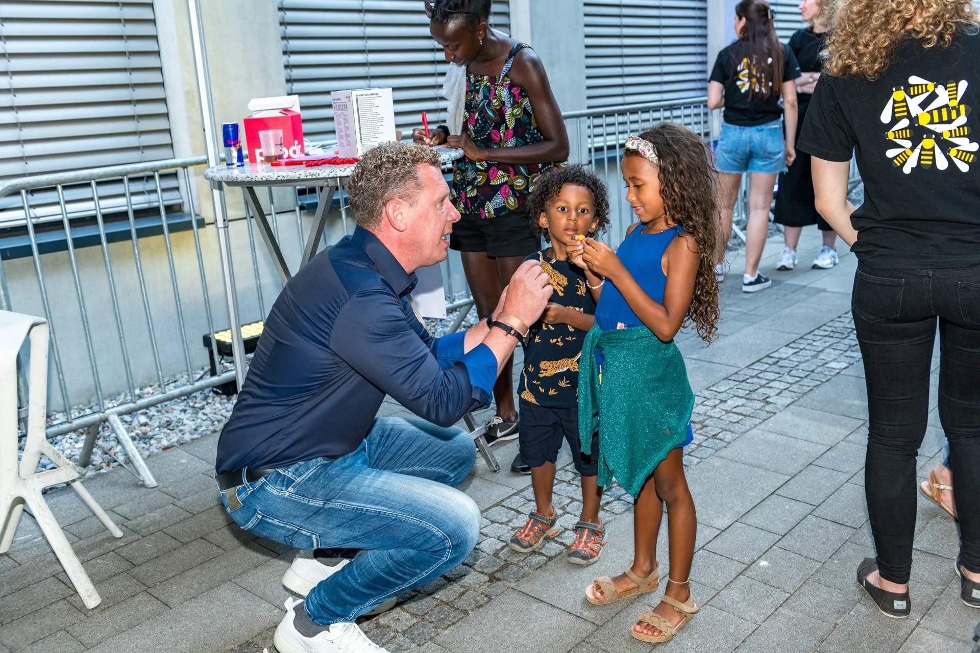 Bernhard Heinzle zeigt zwei Kindern Ohropax für das Schaffarei Festival
