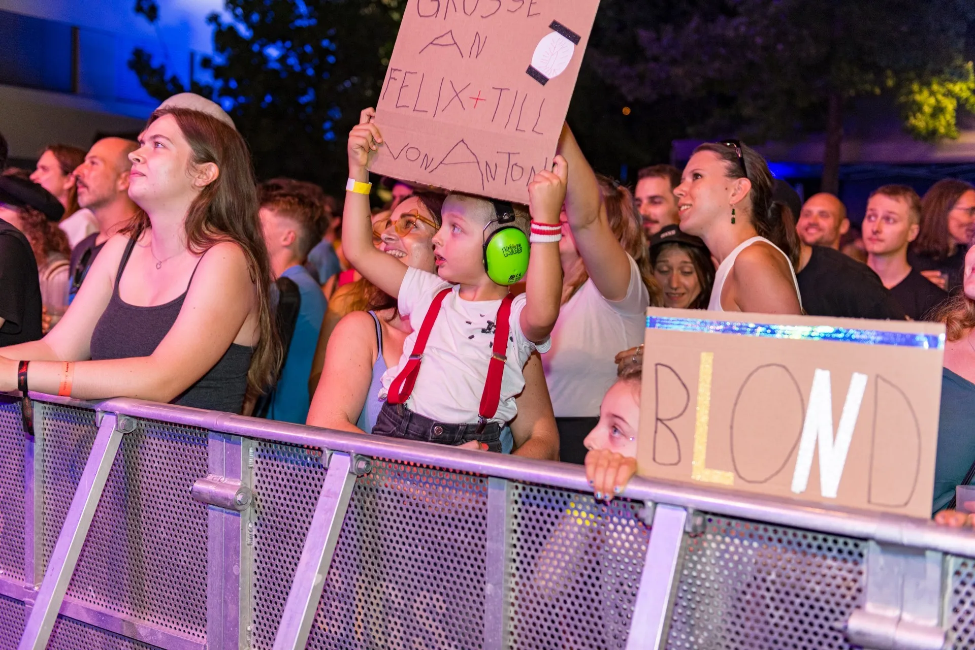 Publikum mit beschrifteten Plakaten auf dem Schaffarei Festival