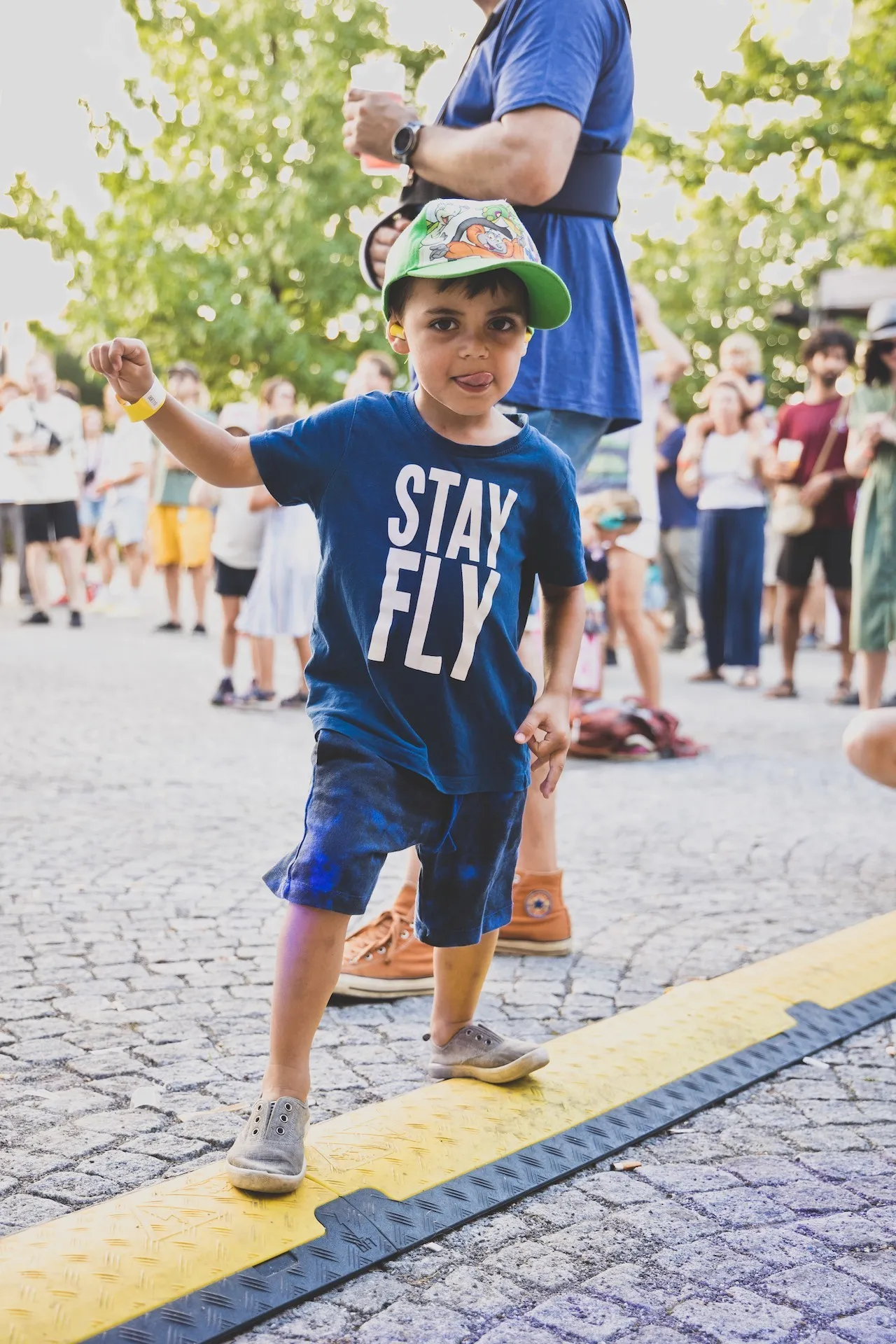 Junge mit blauem Outfit und Baseballcap beim Balancieren