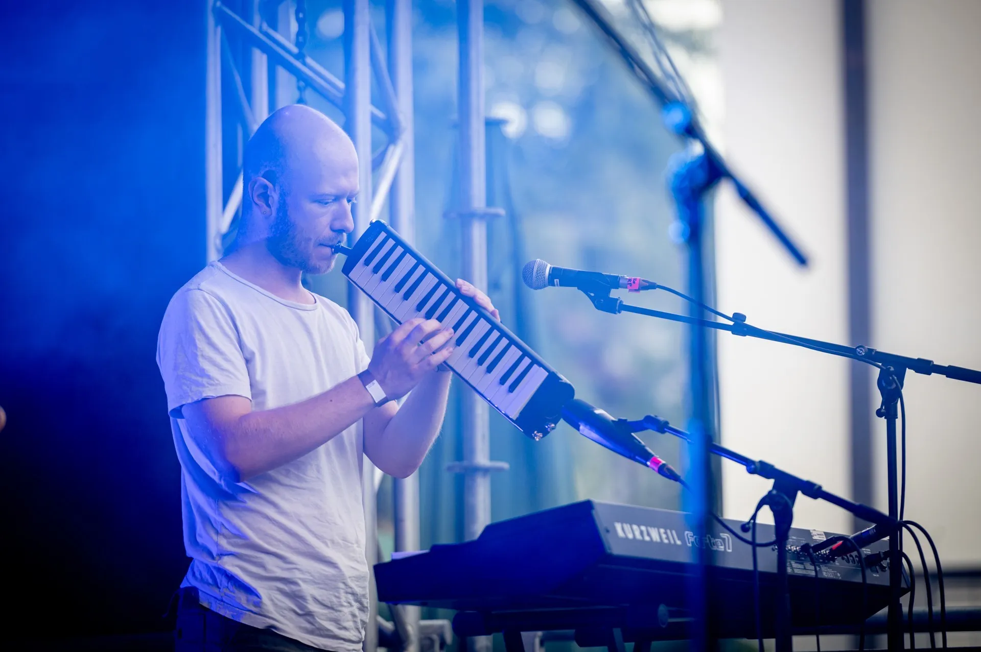 Mann mit weißem T-Shirt und Piano in der Hand