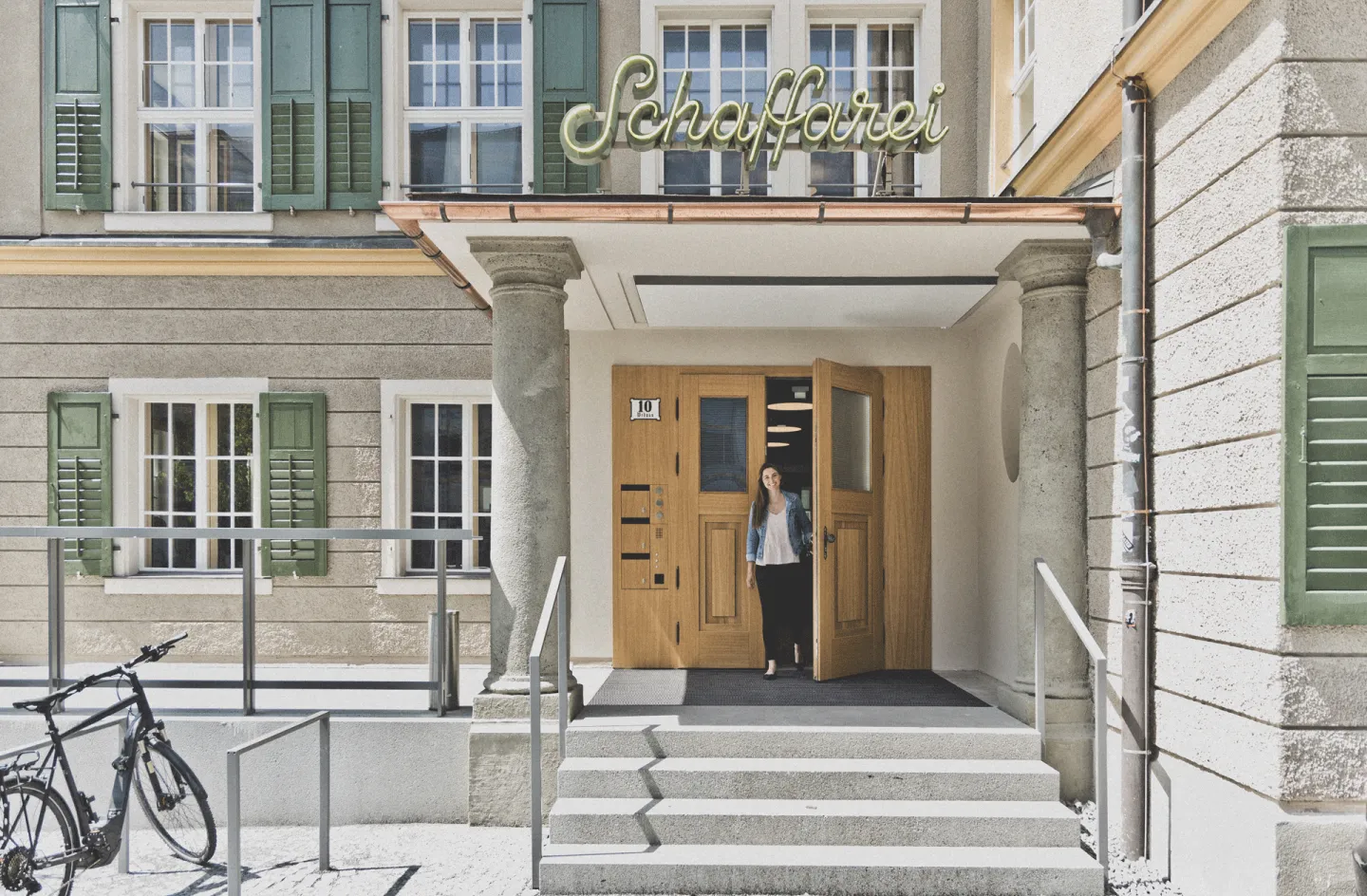 Geöffnete Haustüre des neuen Schaffarei Hauses mit Person