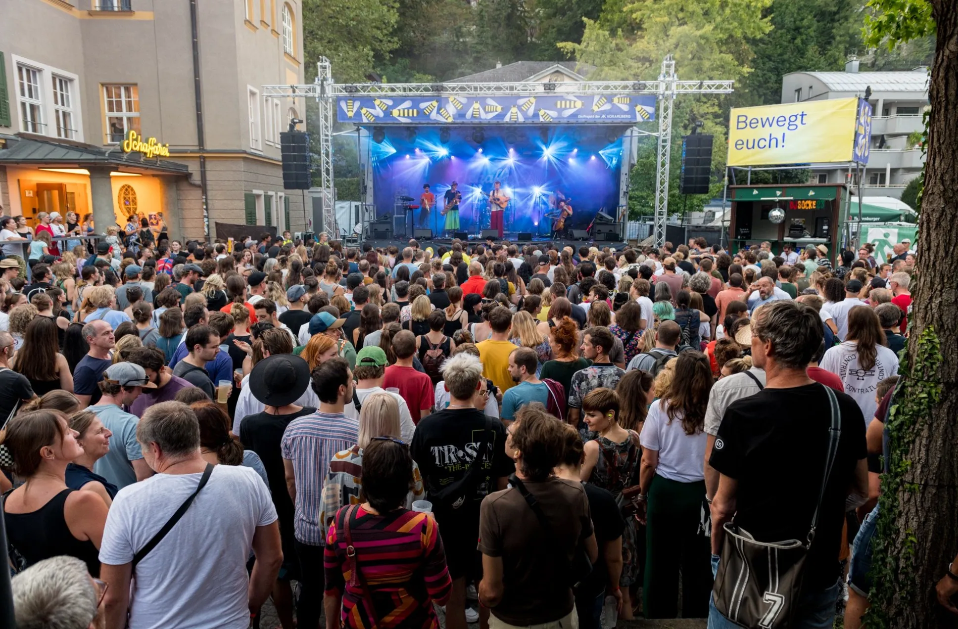 Blick von hinten über den vollen Platz während Buntspecht auf der Bühne spielt