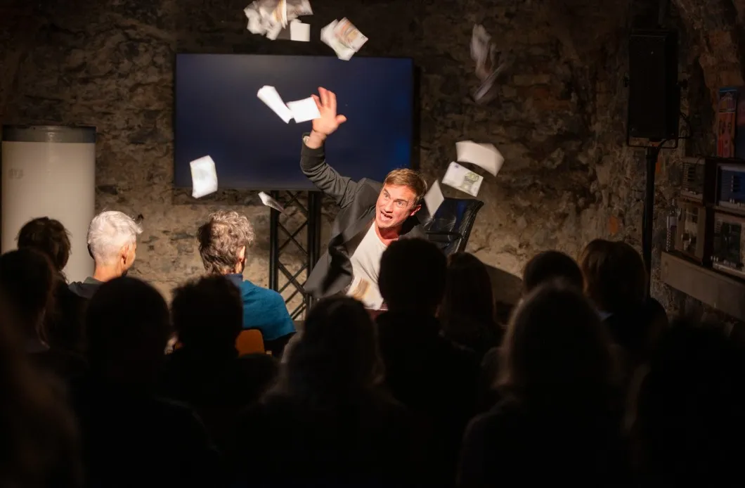 Schauspieler David Kopp der "symbolisches Geld" ind das Publikum wirft