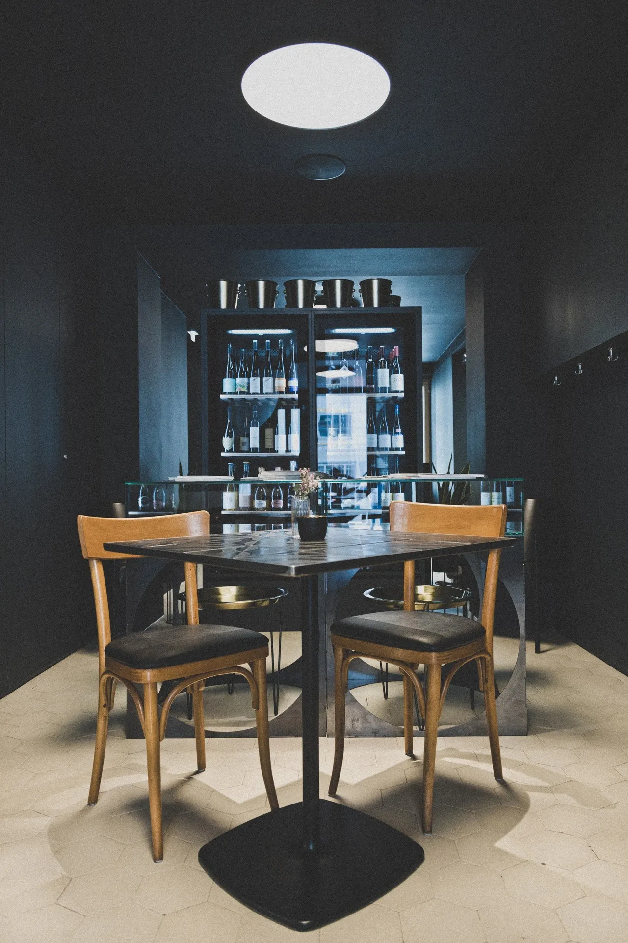 Lokal Hunger und Durst Tisch und Stühle vor Weinschrank